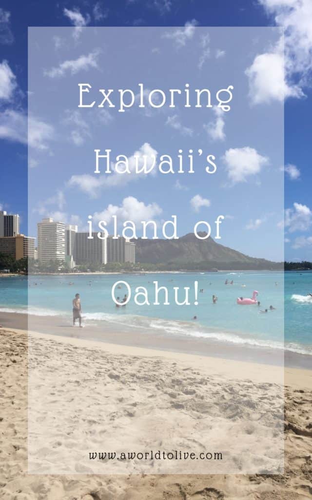 A beach on a sunny day with tall hotels and a mountain in the background. text over image saying; Exploring Hawaii’s island of Oahu!