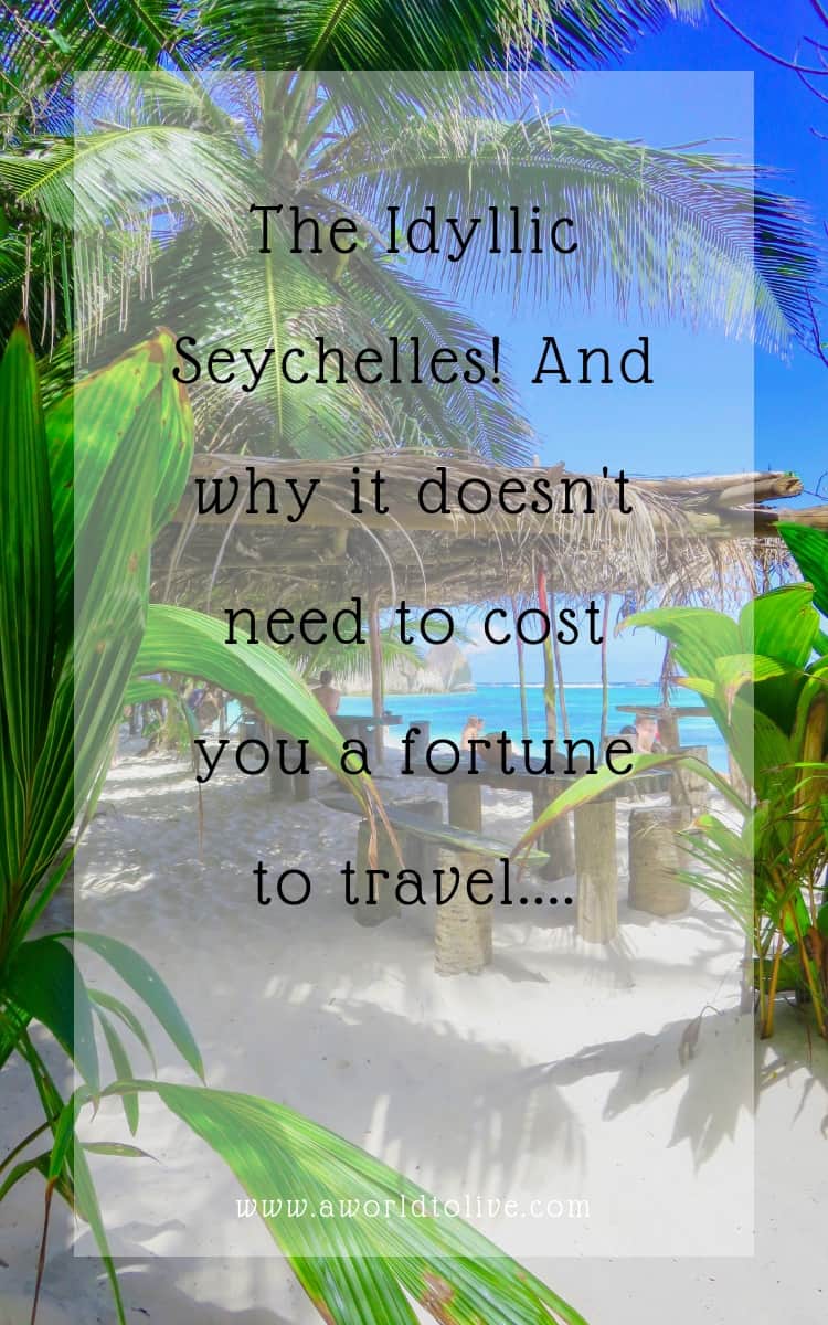 Wooden seats and table on beach, view of the ocean. Text over photo; The Idyllic Seychelles! And why it doesn't need to cost you a fortune to travel