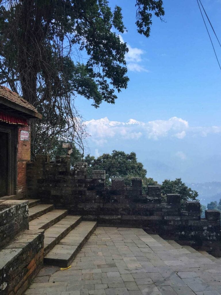 Old pavement and step at Gorkha Royal Palace with clouds and snow covered mountains in the background
