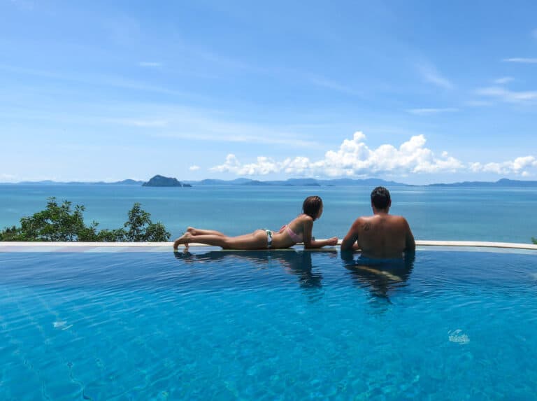 man and women in pool overlooking ocean in Santhiya resort