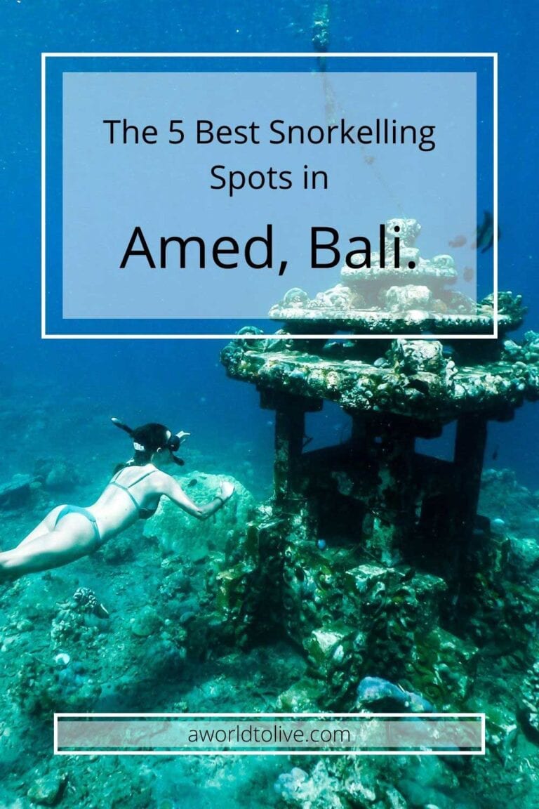 Elyse underwater swimming next to a temple at a snorkeling site in Amed, Bali