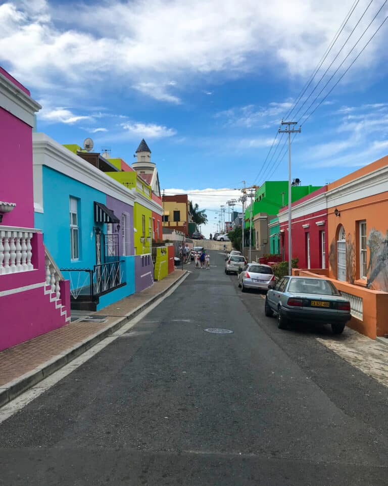 A street in Cape Town, all the houses lining the street are painted in bright colors.