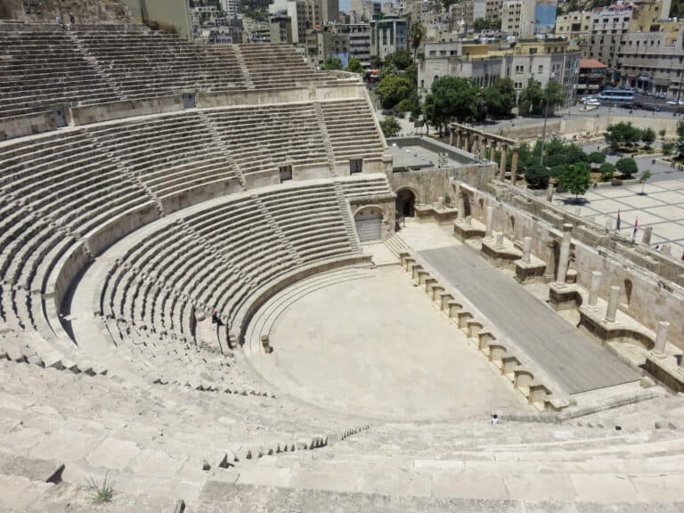 A semicircle Sharpe theater made of concrete and stone. the seating is a stair case to the bottom where the stage is.