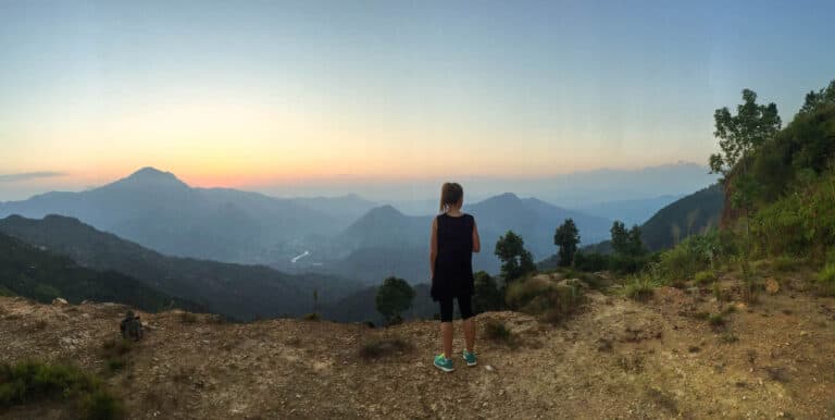 Lady standing up looking to horizon, mountain views at sunrise