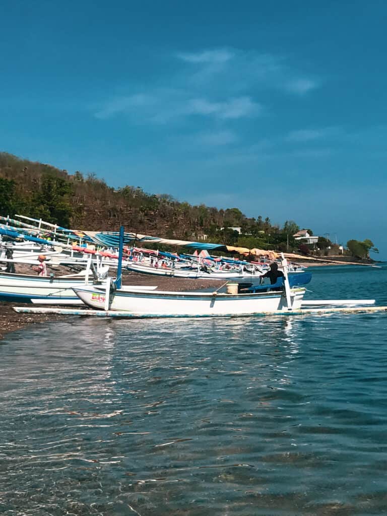 Local Balinese boats are on the blue water in amed