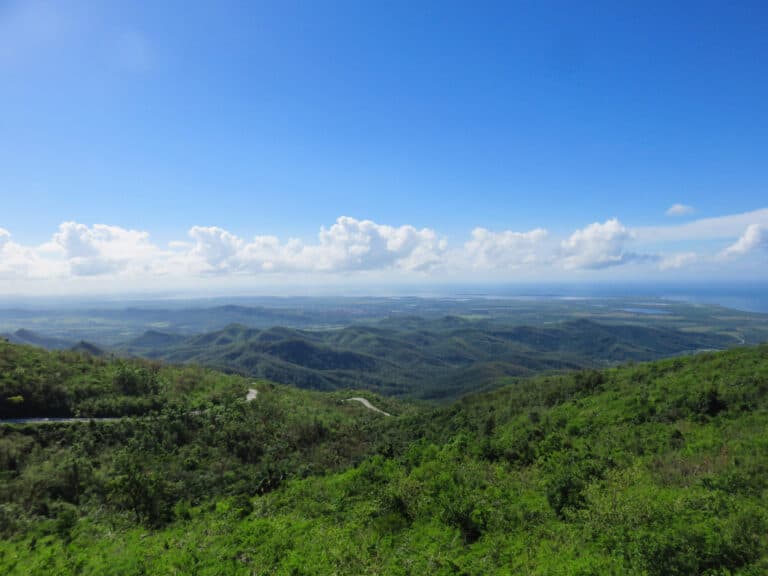 Take from a high lookout, a wide view of a green valley in Cuba
