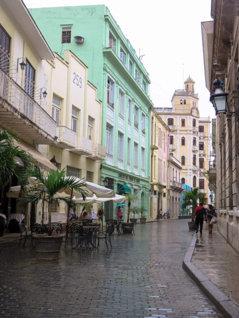 A modern street on a raining day. the buildings are pastel yellow and green colors