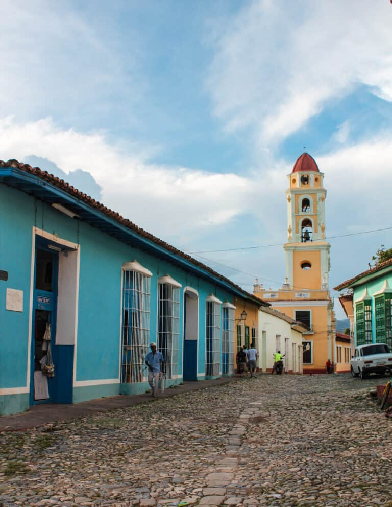 Colorful buildings line the cobble stone streets and Trinidad bell tower standing tall and bright yellow.