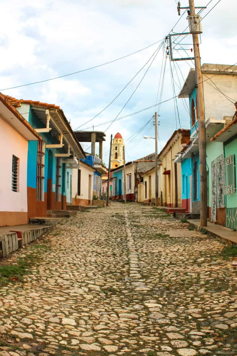 Colorful buildings line the cobble stone streets and Trinidad bell tower standing tall and bright yellow.