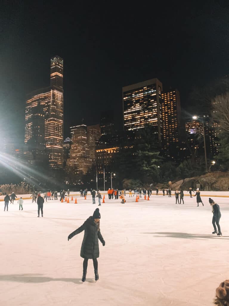 Elyse is Ice skating in Central Park, on of New York City experiences. The photo is taken at night