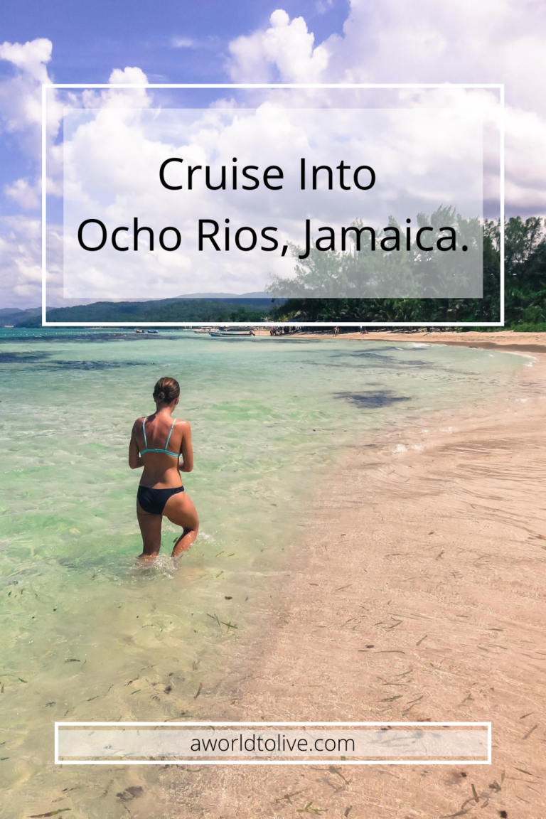 Elyse walking down the shore line of a beach on a sunny day. The Ocho Rios cruise port and ship can be seen in the distance. Text is written over image saying; Cruise into Ocho Rios, Jamaica.