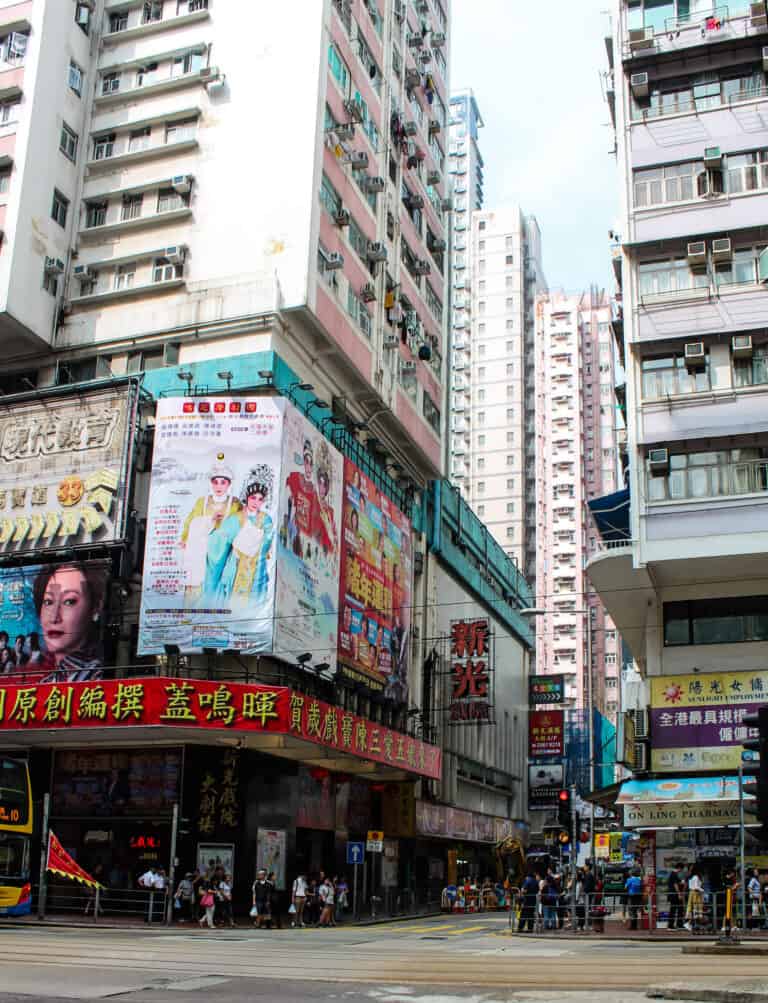 Busy city streets, the shops are on ground level and above are tall apartment buildings