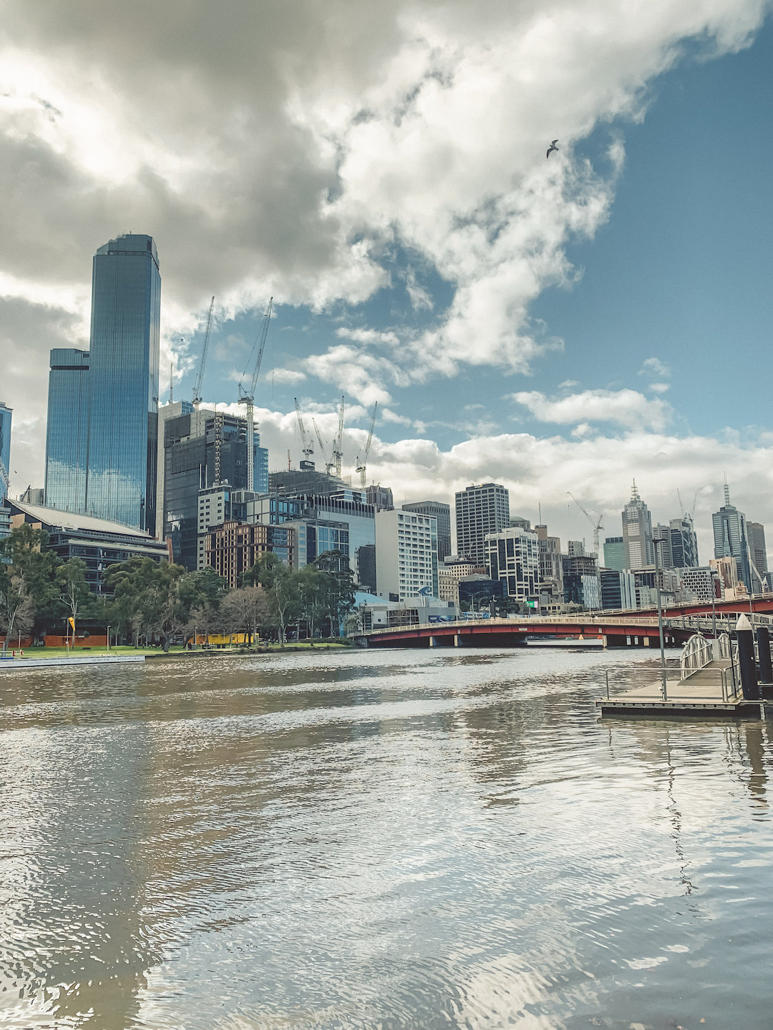 The Yarra river running through the Melbourne CBO. On the other side of the river are tall office buildings.