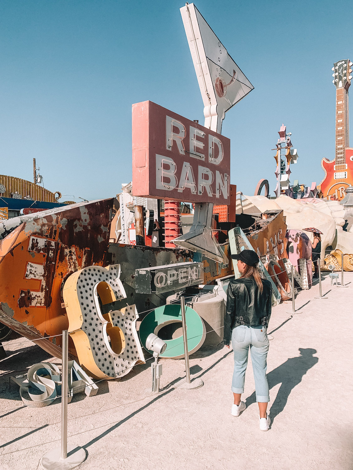 Elyse walking in the Neon Museum, in front of her are old neon signs leaning up against each other. A holiday that is included in my recap of the year.