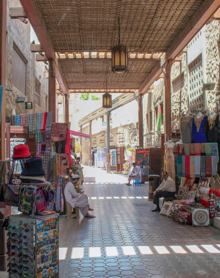 A market under wooden roofing, as discussed in the Dubai travel guide, this area is great for shopping and both side of the path are lined with local textile stores.