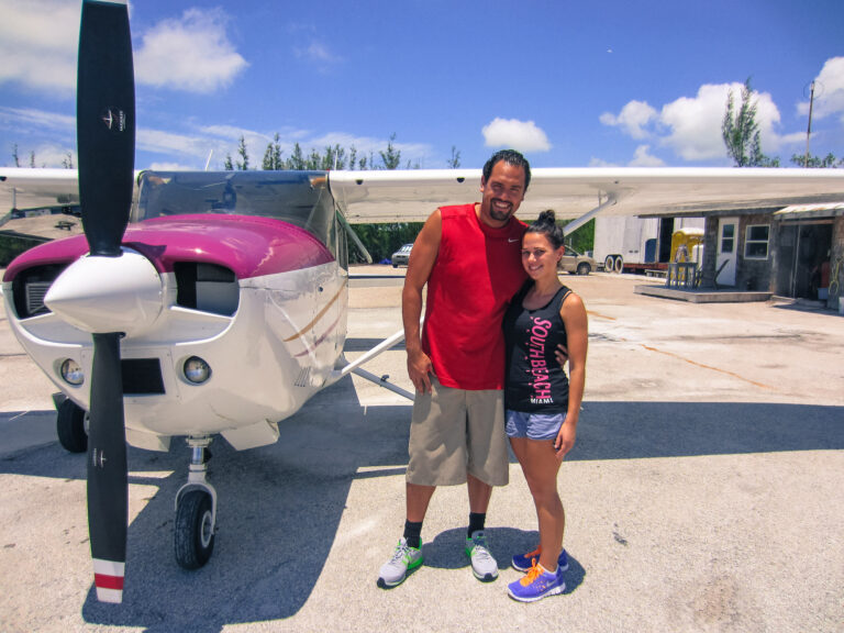 A male and female standing next to a small aircraft in Miami.