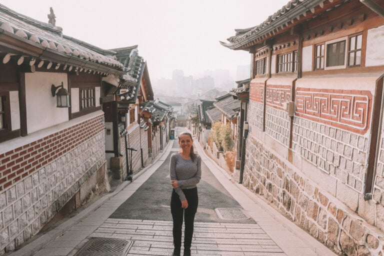 Elyse standing in the middle of a quiet road in Bukchon Hanok Village, something she recommends doing if you travel to Seoul