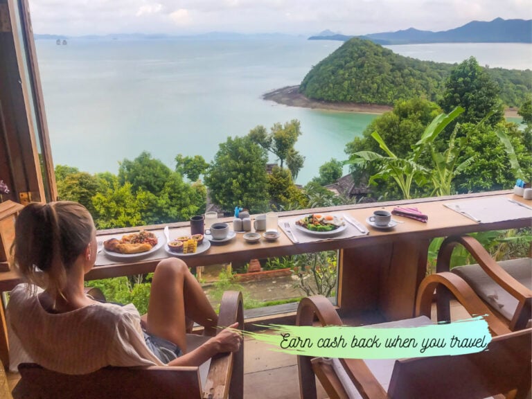 Elyse Sitting at a bunch, eating breakfast and overlooking the ocean view. Text on image advising to get cashback on travel