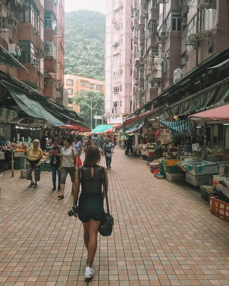 Elyse walking through a local market to save money while she travels