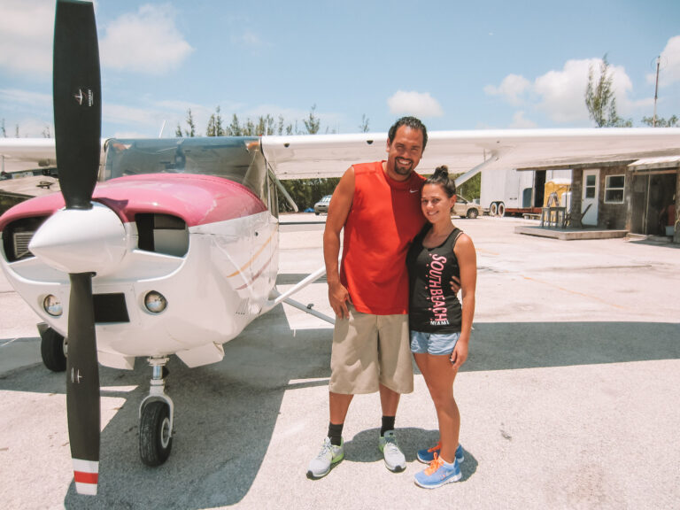 Elyse and Lawrence standing in front of a small pink airplane. Before they skydived over sky west, one of the 14 best travel experiences