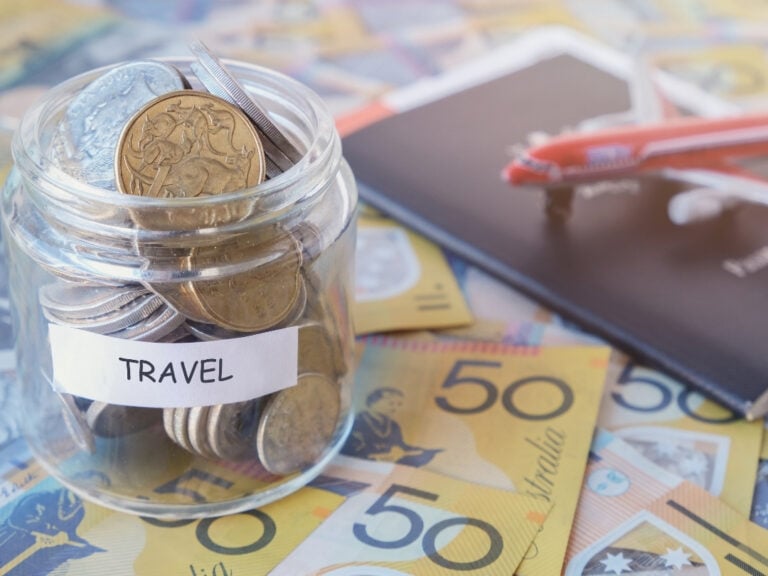 a close up image of Australian cash, Australian passport and a model airplane.