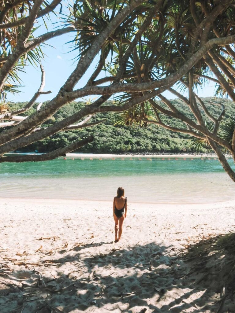 Elyse standing on the sand at Tallebudgera Creek on a sunny day. Talley creek is one of the best beaches on the Gold Coast