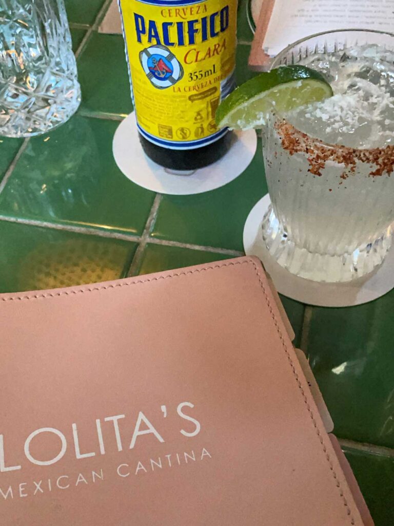 A close up image of a beer, margarita and pink colored menu at a Mexican restaurant near tweed heads