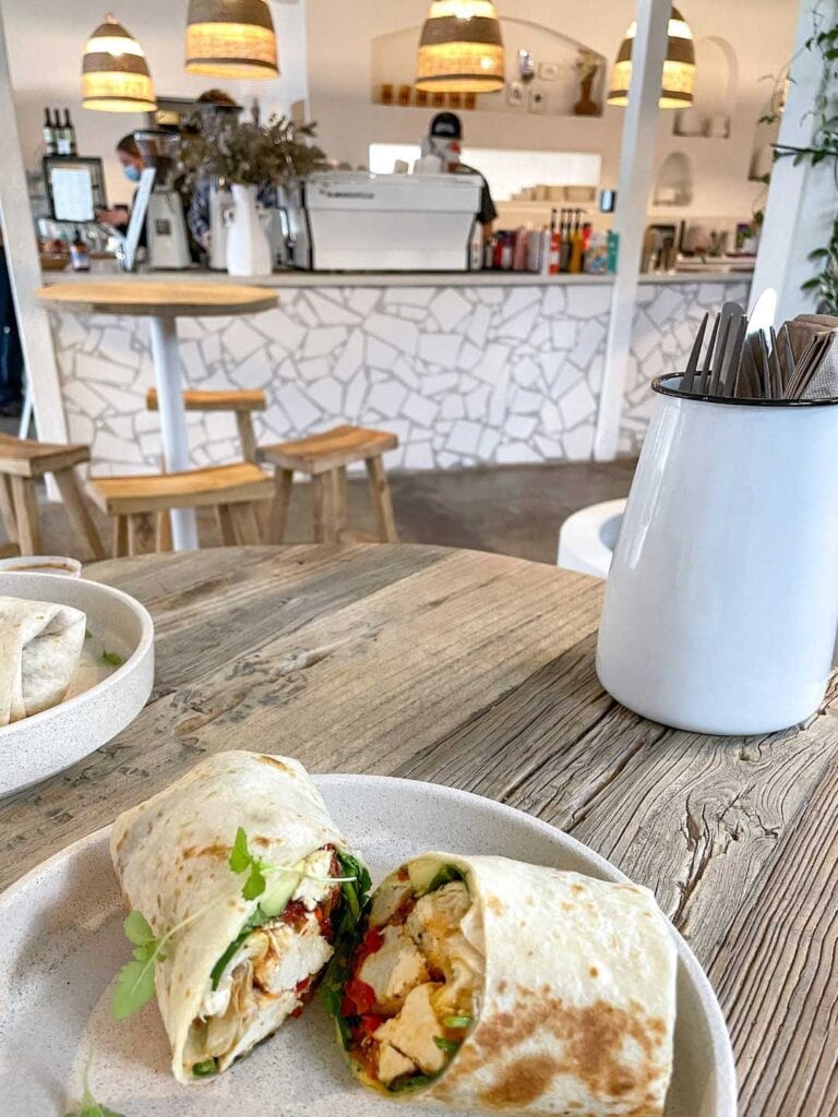 A vegan wrap served at a restaurant in tweed heads. The counter and coffee machine can be seen beyond the table