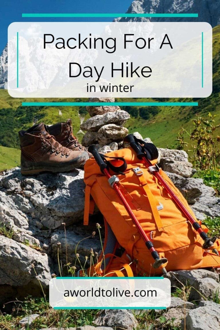 List article on packing for a day hike in winter. A backpack, hiking poles and hiking boots are leaning on a rock