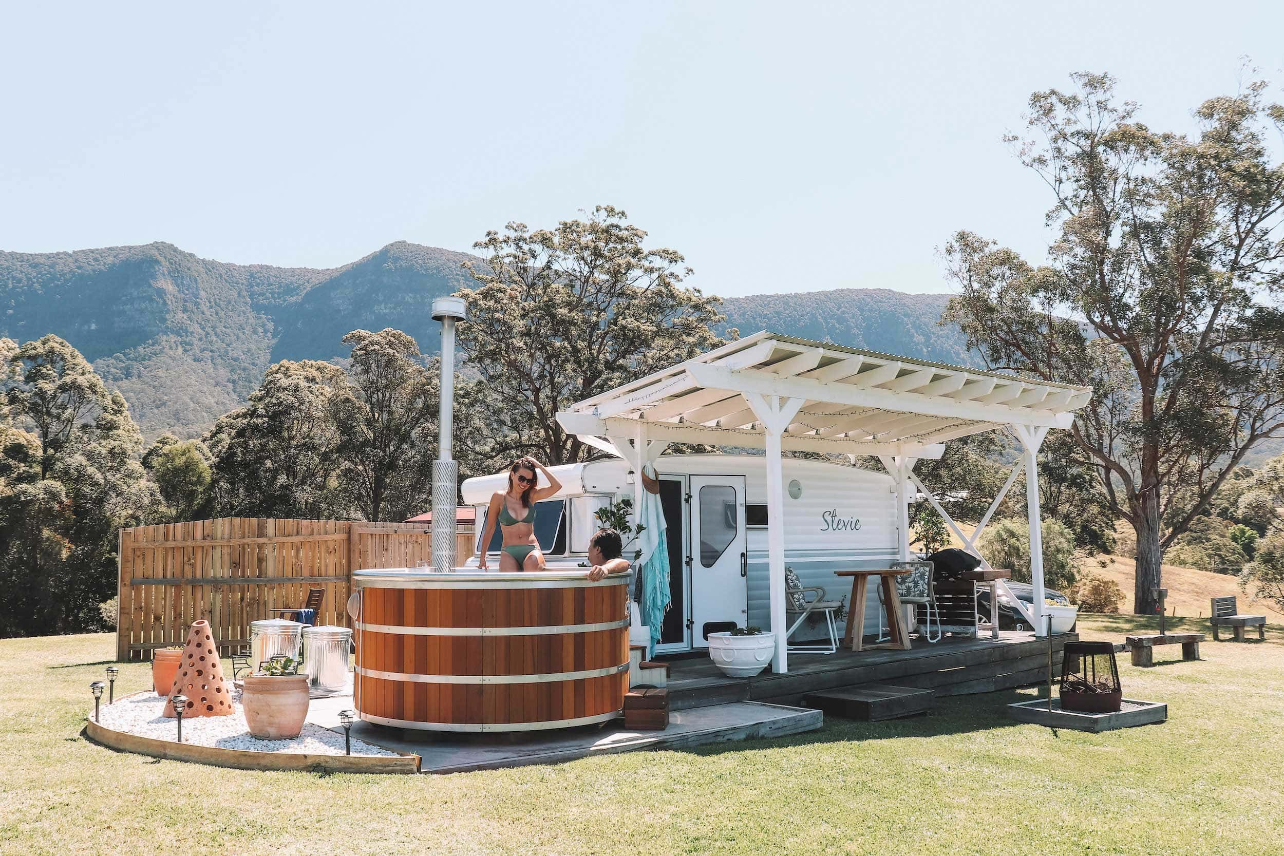 taken in front of Stevie stay, a romantic getaway in northern NSW listed on Airbnb. A retro caravan decked out and next to the van is a hot tub