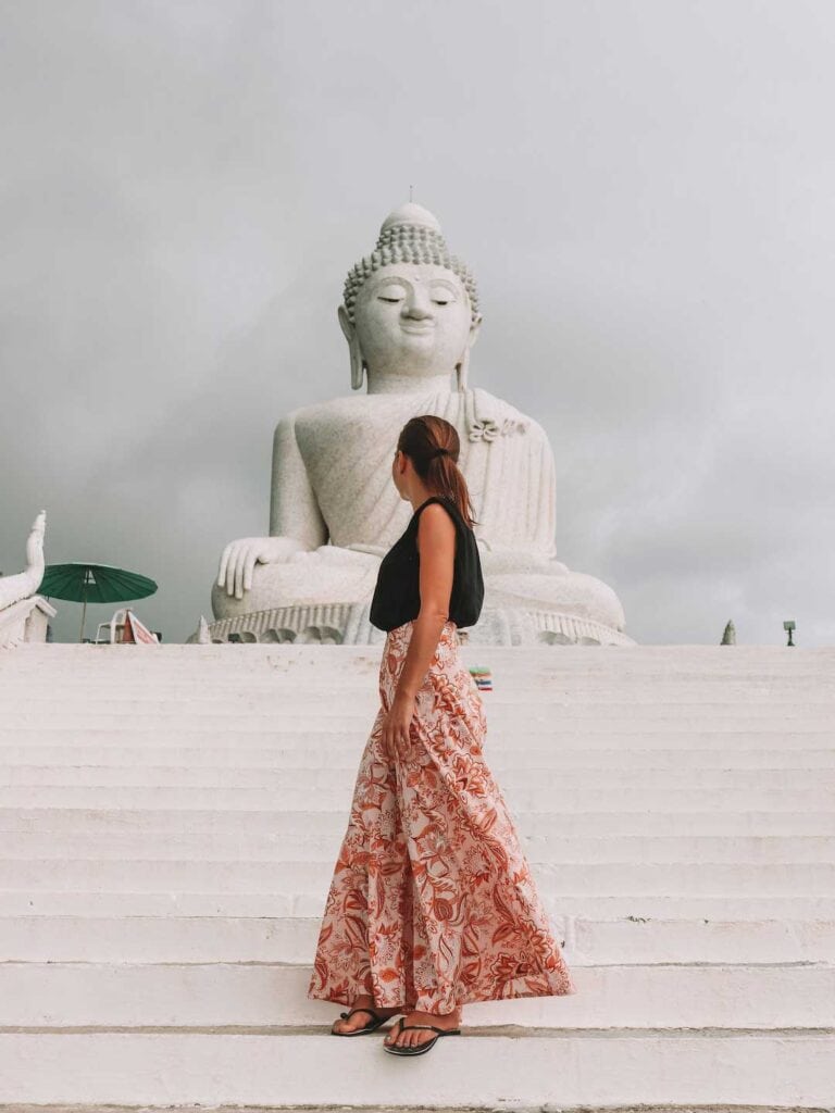 Elyse standing in front of the big Buddha in Phuket on a cloudy day