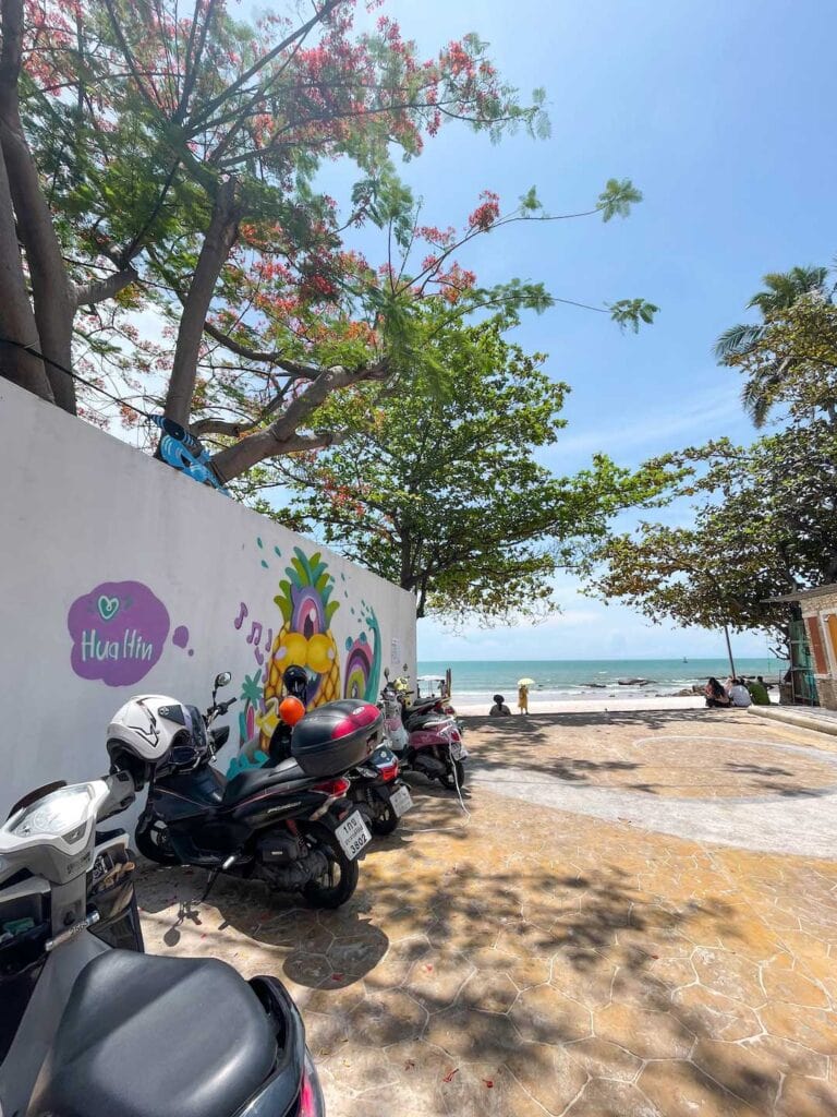 scooters parked at the main beach and the wall is decorated with colorful artwork
