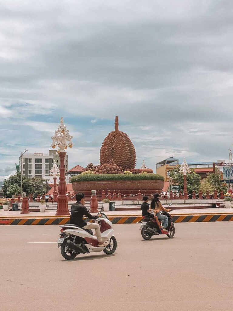Motorcycles passing the famous durian roundabout in Kampot, which is in Southern Cambodia