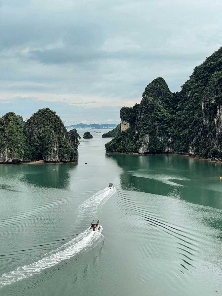Halong Bay in North Vietnam. two boats sailing over the green water and between the large limestone cliffs. This destination is recommended in the travel guide This meal is recommended in guide things to know before traveling to Vietnam