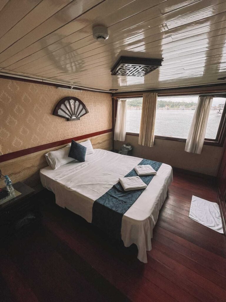 Inside the ships cabin, a large double bed and windows looking out to the scenery