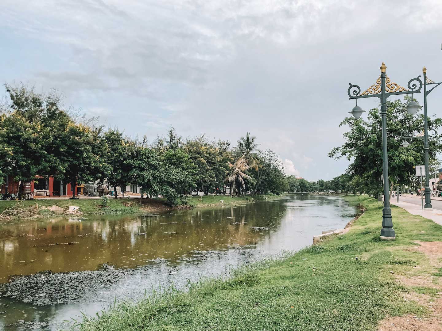 Walking along Siem Reap River on a cloudy day, one of the free things to do in Siem reap besides temples