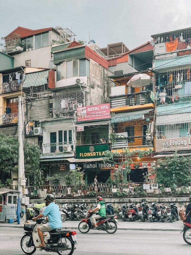 motor bikes passing thr bright and cramped buildings in Hanoi Old Quarter