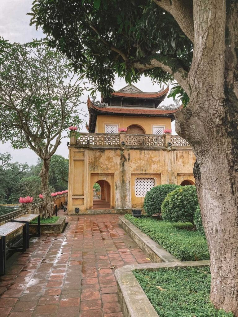 An old building in Hanoi's Citadel, the building is yellow and surrounded with well manicured gardens. visit day 1 of this 7 day north Vietnam itinerary.