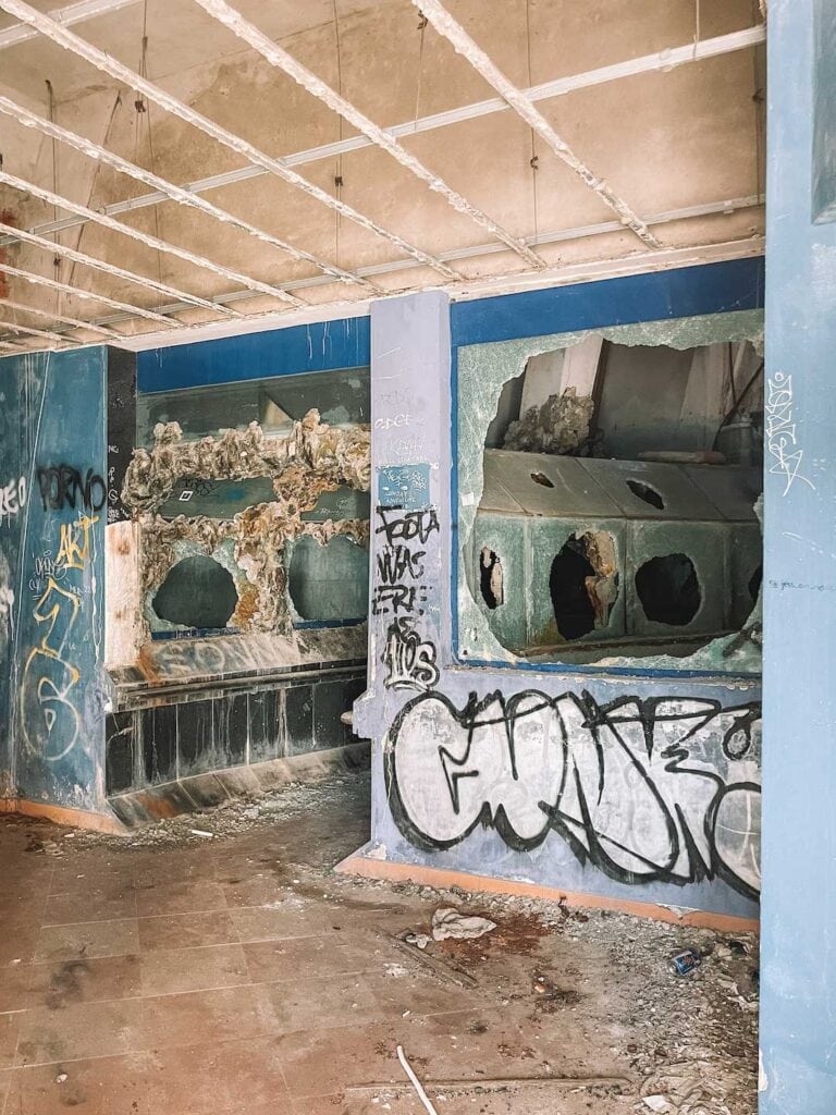inside the abandoned aquarium. All the glass on the tanks is smashed and the walls are covered in graffiti