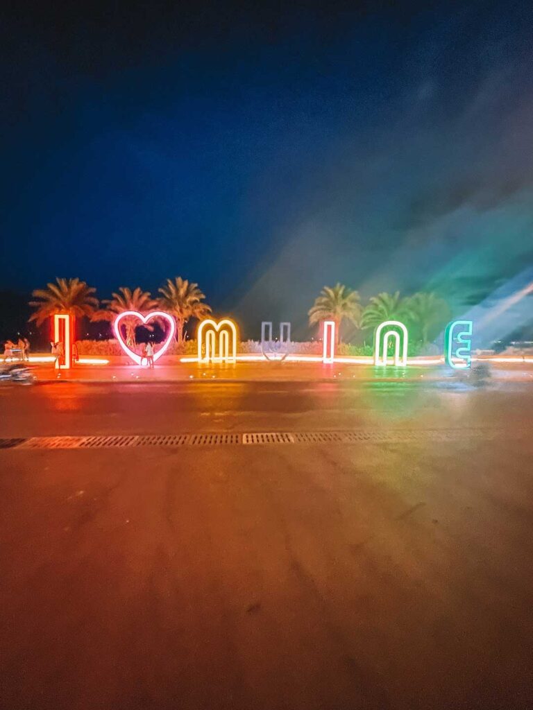Bright neon sign spelling out I (heart) Mui Ne