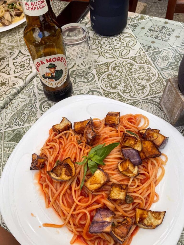 eggplant pasta served with a local beer