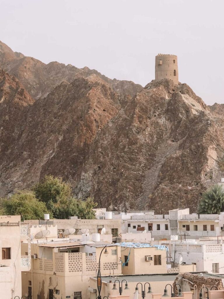 Scenic views of Muscat and part of a fort perched on top of the rugged mountains