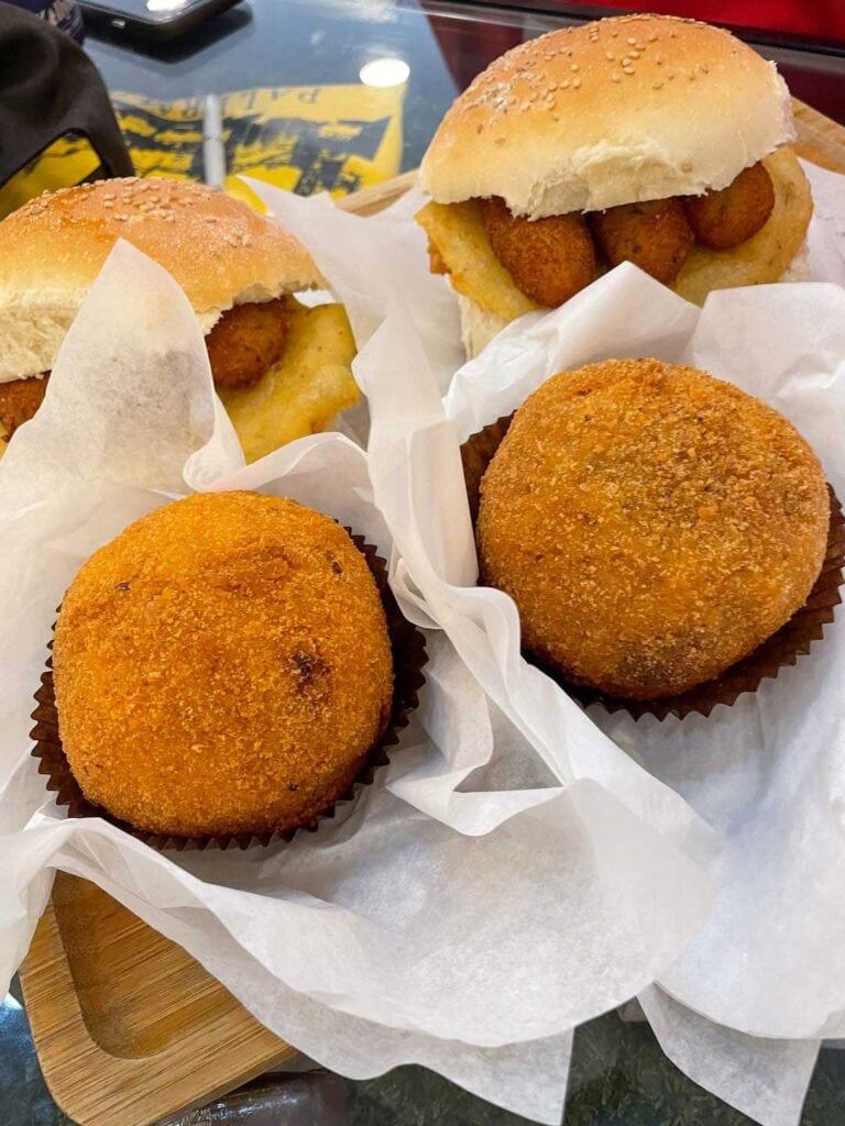 street food in sicily. arancini balls and Panelle & Croquette sandwiches.