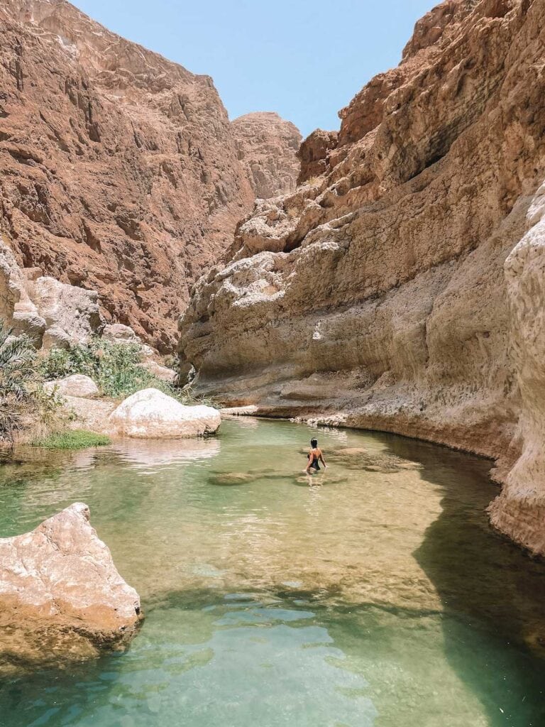 In the water of Wadi Shab in Oman. Stop over during a road trip in Oman