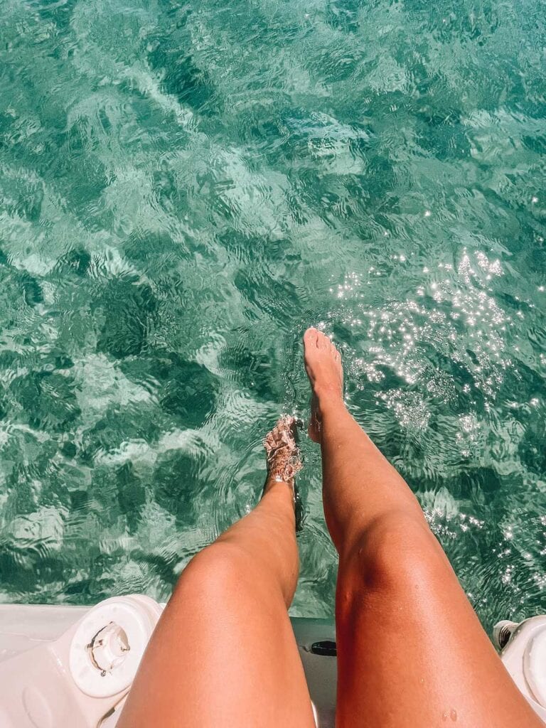 legs in the clear ocean at Baia di Cornino beach