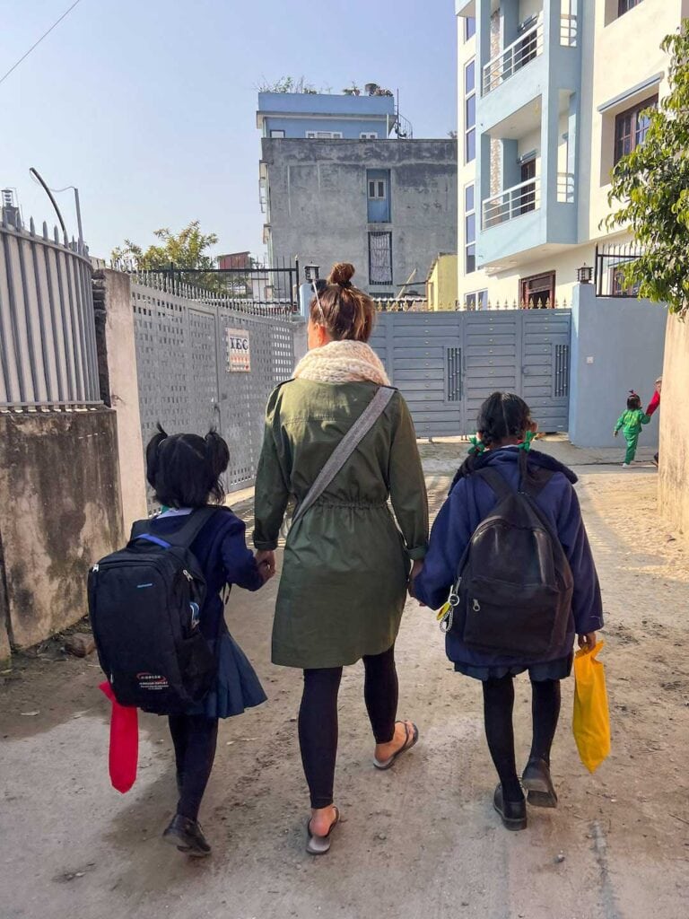 Elyse walking two children to school who are sponsored by IGWR