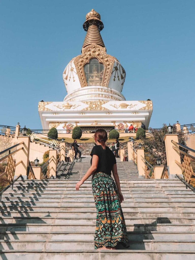 Elyse standing in front of Jamchen Vijaya Stupa in Kathmandu