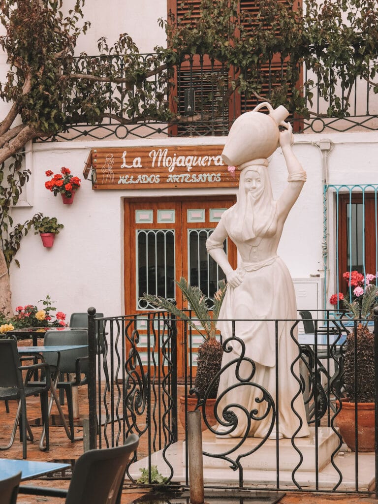 A statute of a lady holding a water jug on her head