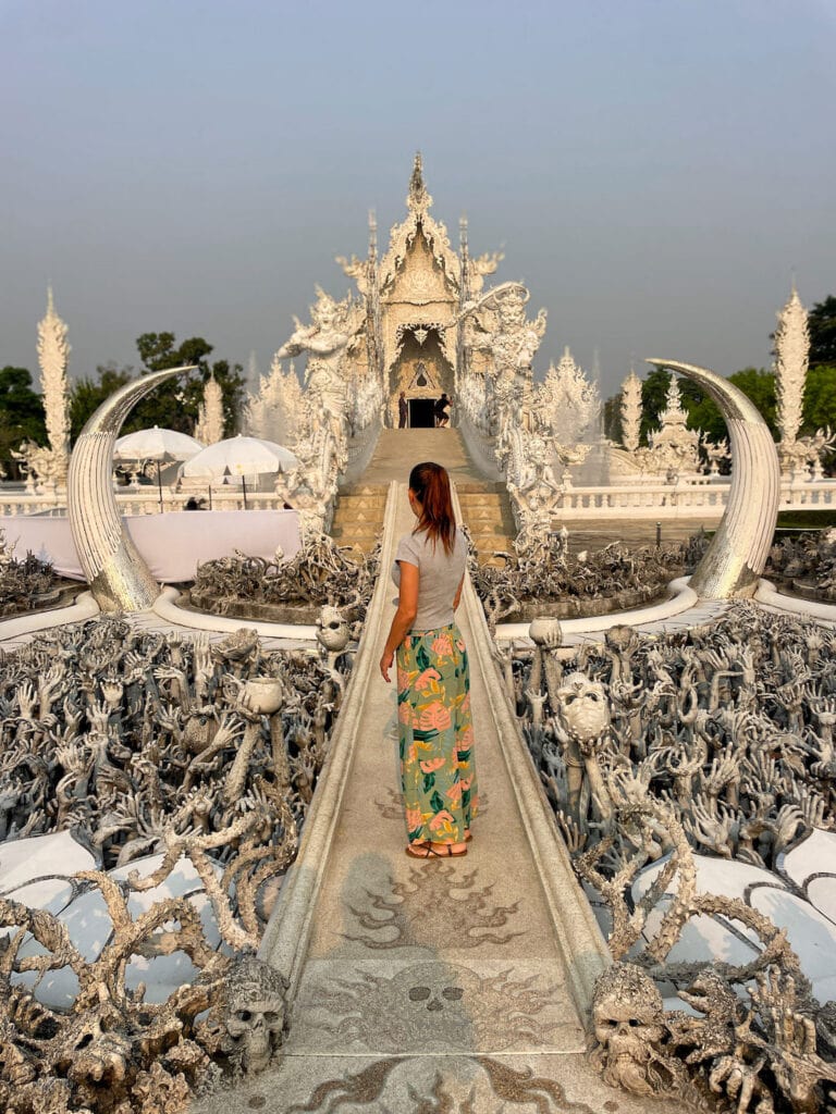 Elyse standing on the bridge towards the main chaple at the white temple in Chiang Rai
