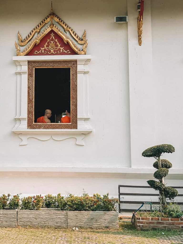 two monks sitting by the window of a temple in Northern Thailand